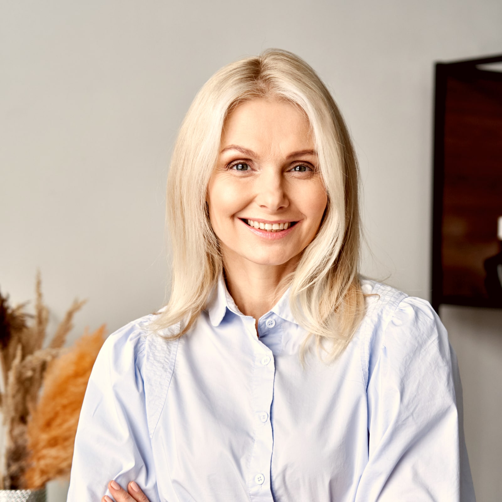 Smiling confident middle aged woman with arms crossed
