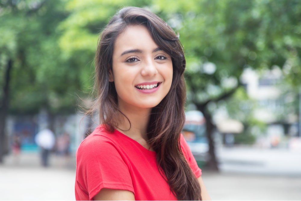 Laughing woman in a red shirt outdoor in a park