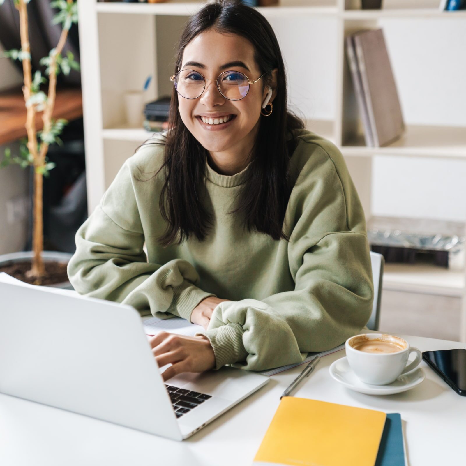 Happy teenage girl studying with a laptop
