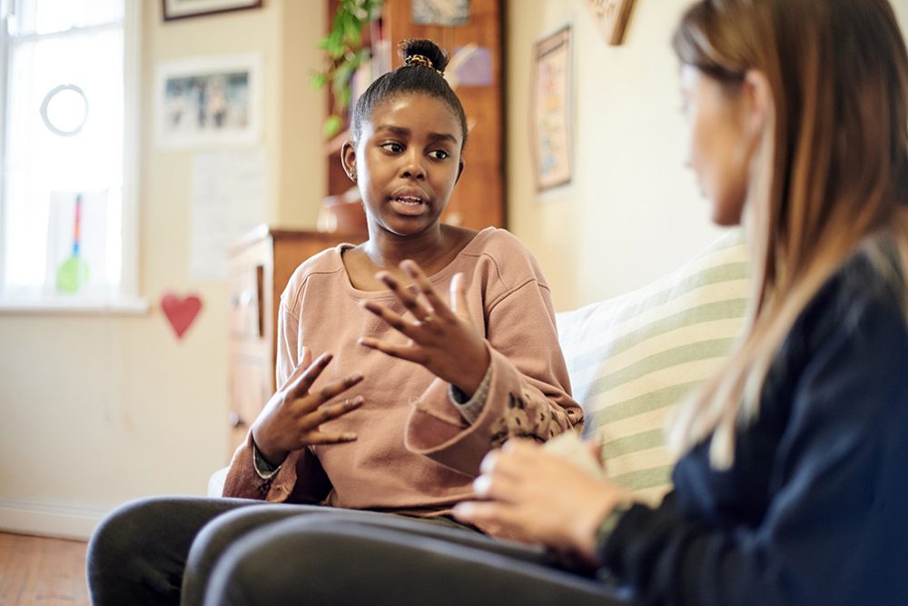 A teen is having a conversation with her therapist in the therapist's office.
