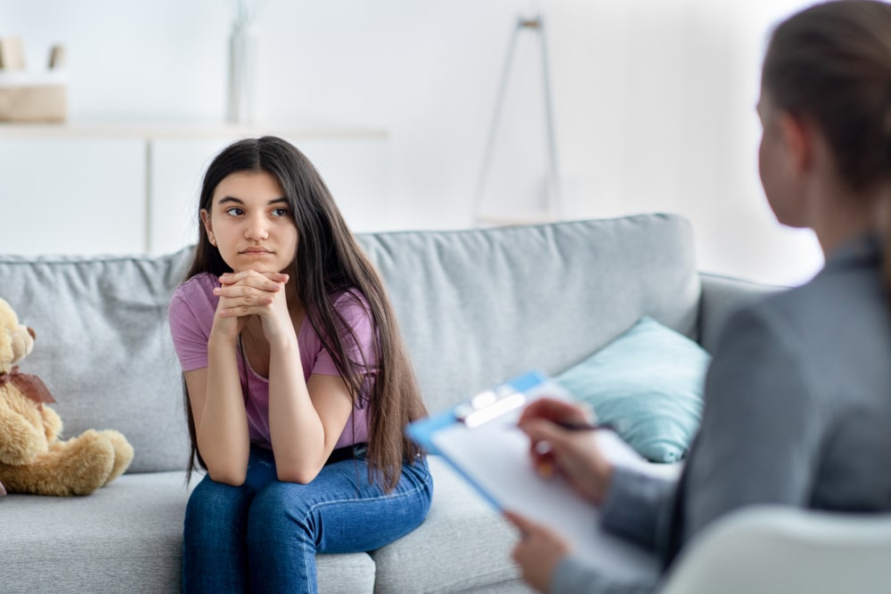 Female psychologist consulting depressed teenage girl