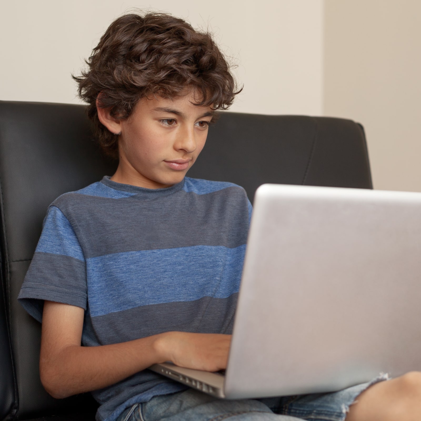 boy sitting on sofa with laptop computer